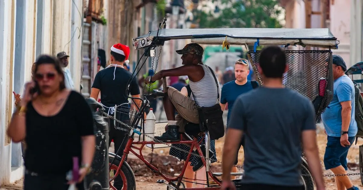 A man driving a bicycle taxi through Havana
