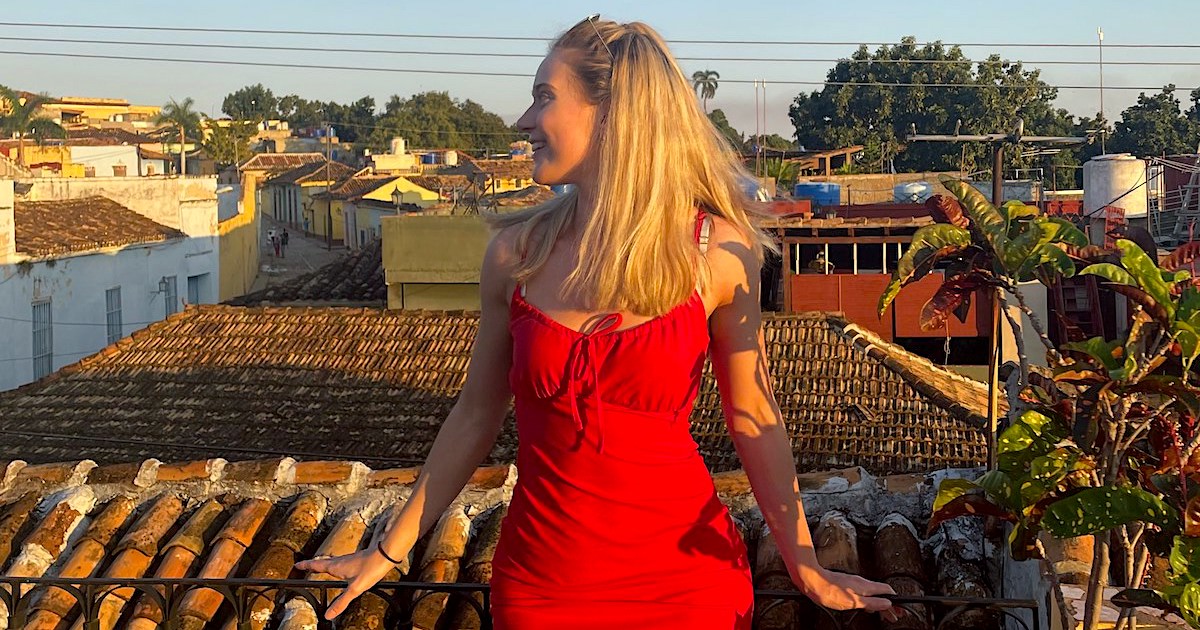 Woman wearing a red dress looking over rooftops