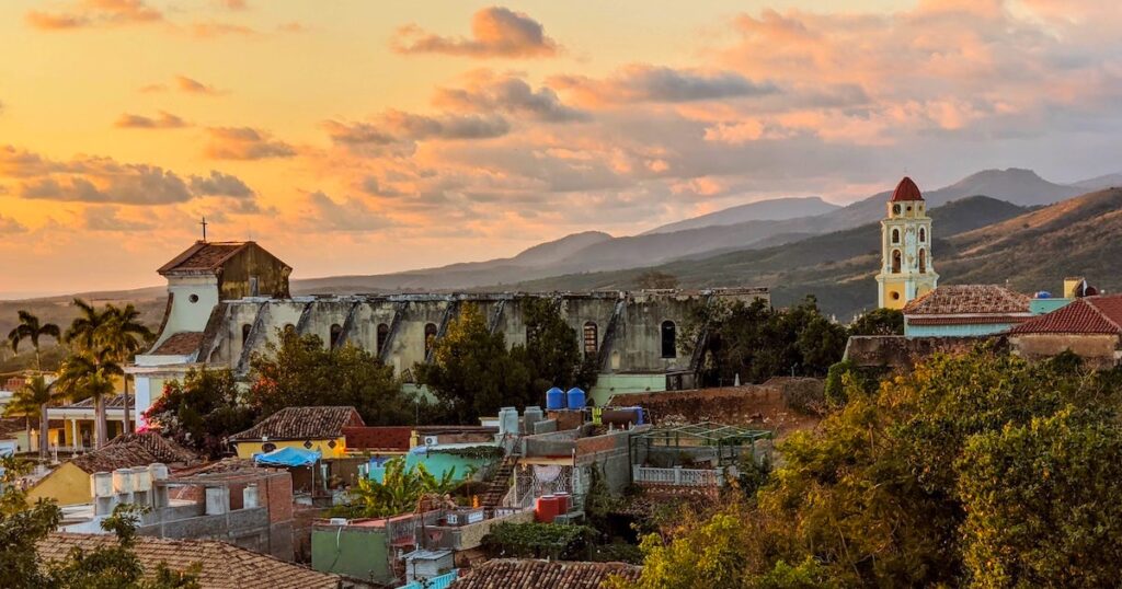 View over rooftops in Trinidad, Cuba, including a church and hills