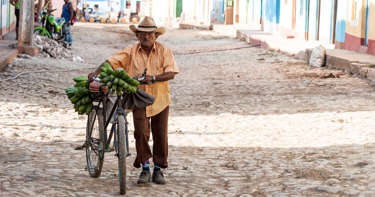 Man pushes a bicycle wearing a cigar shirt