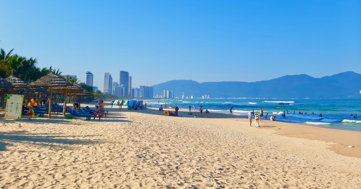 Sandy beach with skyscrapers and mountains