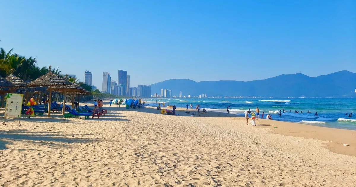 Sandy beach with skyscrapers and mountains