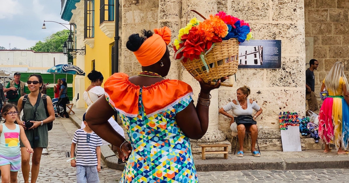 Woman holding a basket and wearing a colourful traditional dress