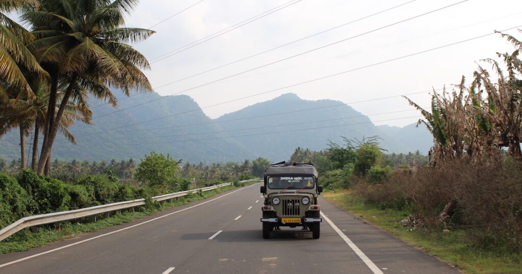 Jeep driving on a rural highway in Tamil Nadu, a day trip from Thekkady in Kerala.