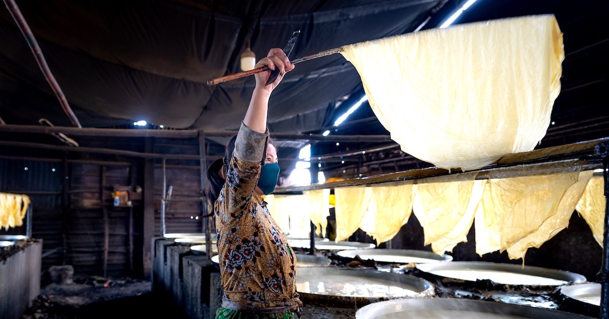 Lady cooks a huge batch of rice paper