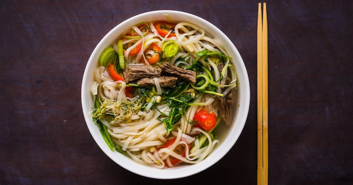 A bowl of pho with rice noodles