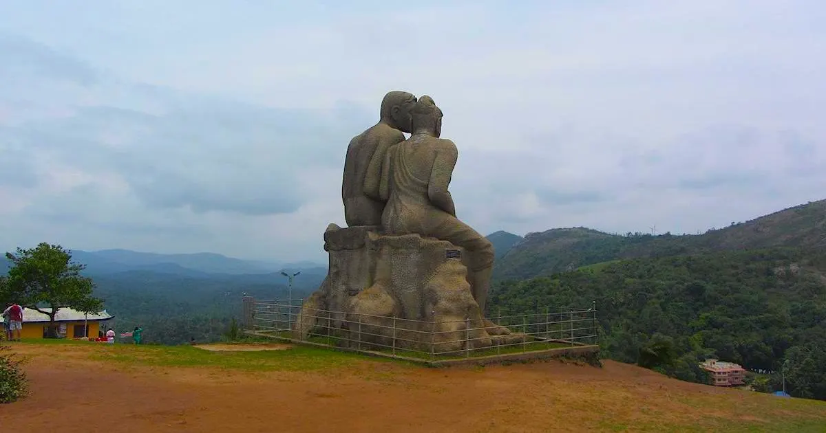Two large, stone statues embrace over a green valley in Ramakkalmedu.