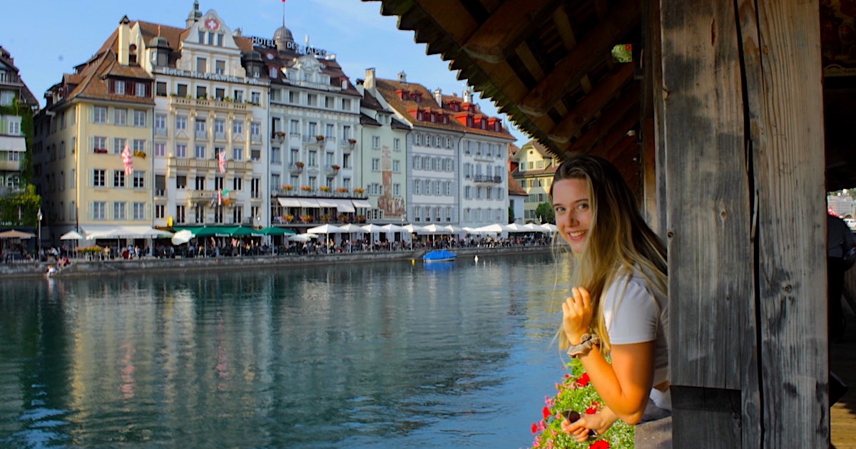 Blogger Escape Artist Katie smiles over the waterfront in Lucerne, Switzerland.