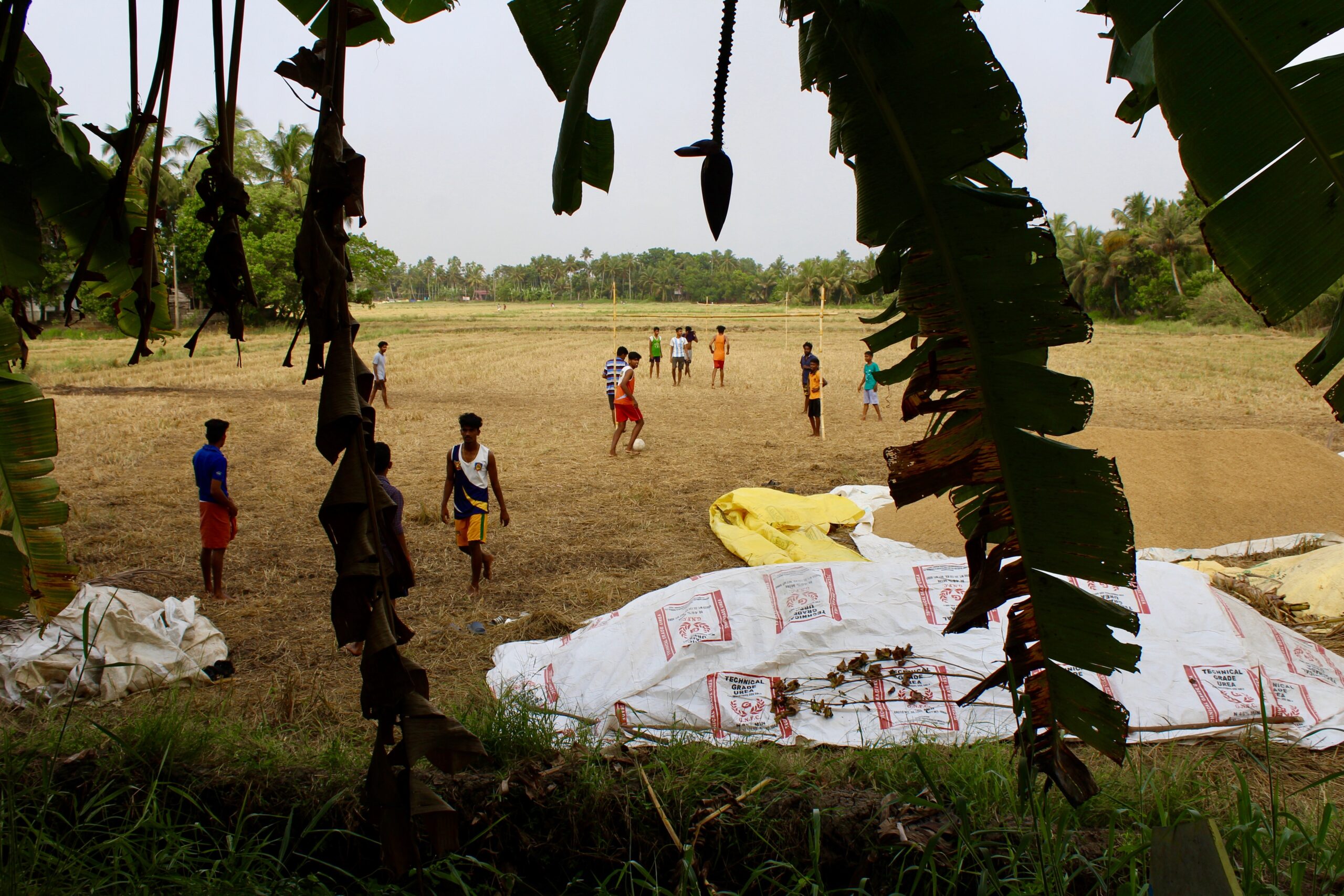 Village schoolboys play football in a recently harvested field.