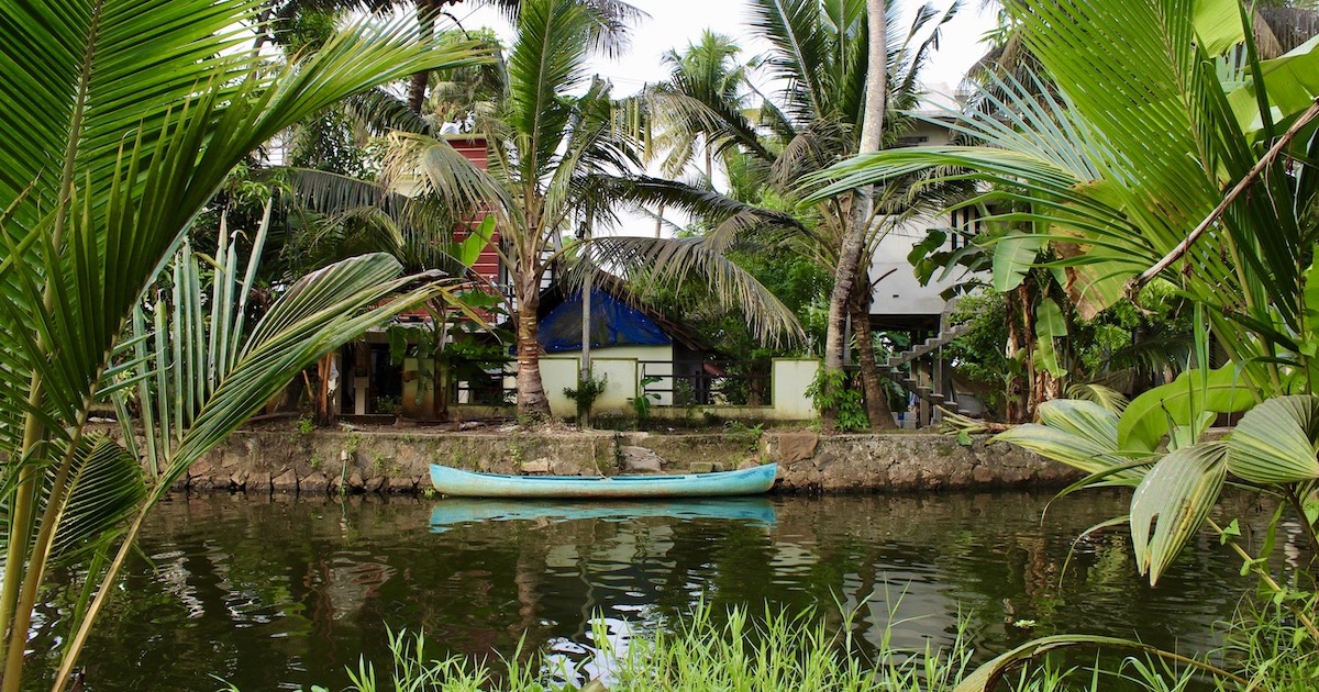 A canoe parked beside a canalside house in a village in Alleppey.