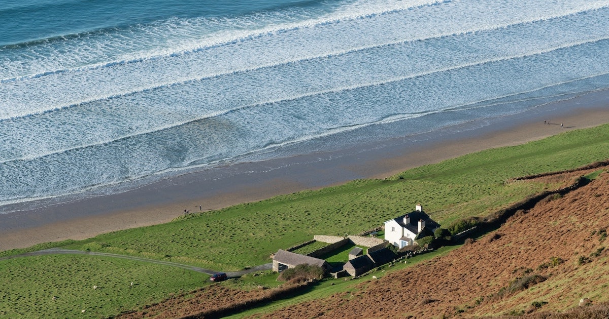 A heritage house on the green bank above Rhossili Bay in Gower.