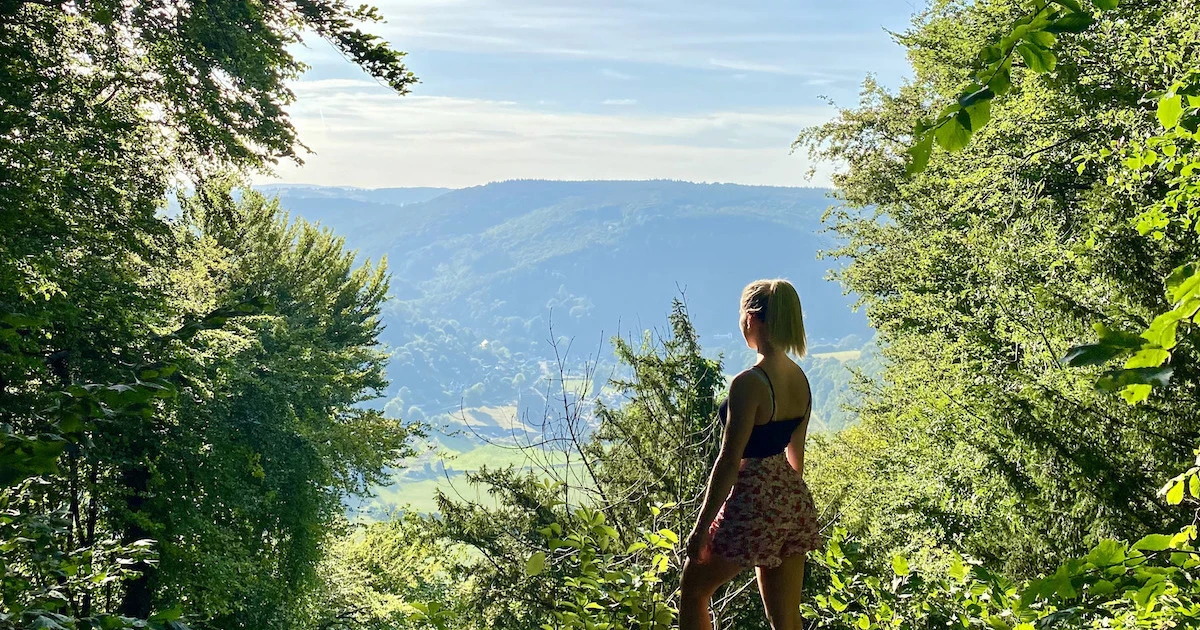 Blonde woman looks out over the Wye Valley from the Devil's Pulpit viewpoint.