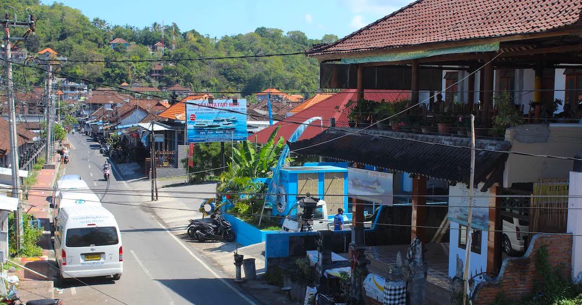 A street lined with vans and houses in Padangbai, East Bali