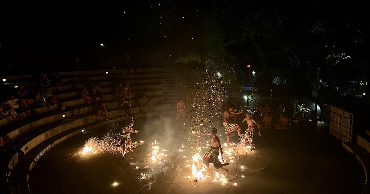 Performers at the Batu Bolong kecak performance in Bali kick fire around a circle.
