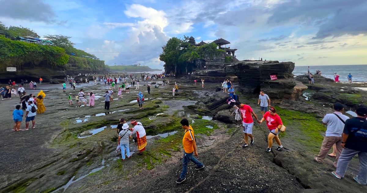 Tanah Lot sunset crowds gather in the main rock bed in front of the temple.