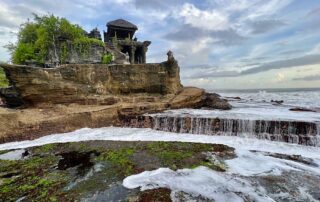 Tanah Lot Temple surrounded by sea water on the rocks.