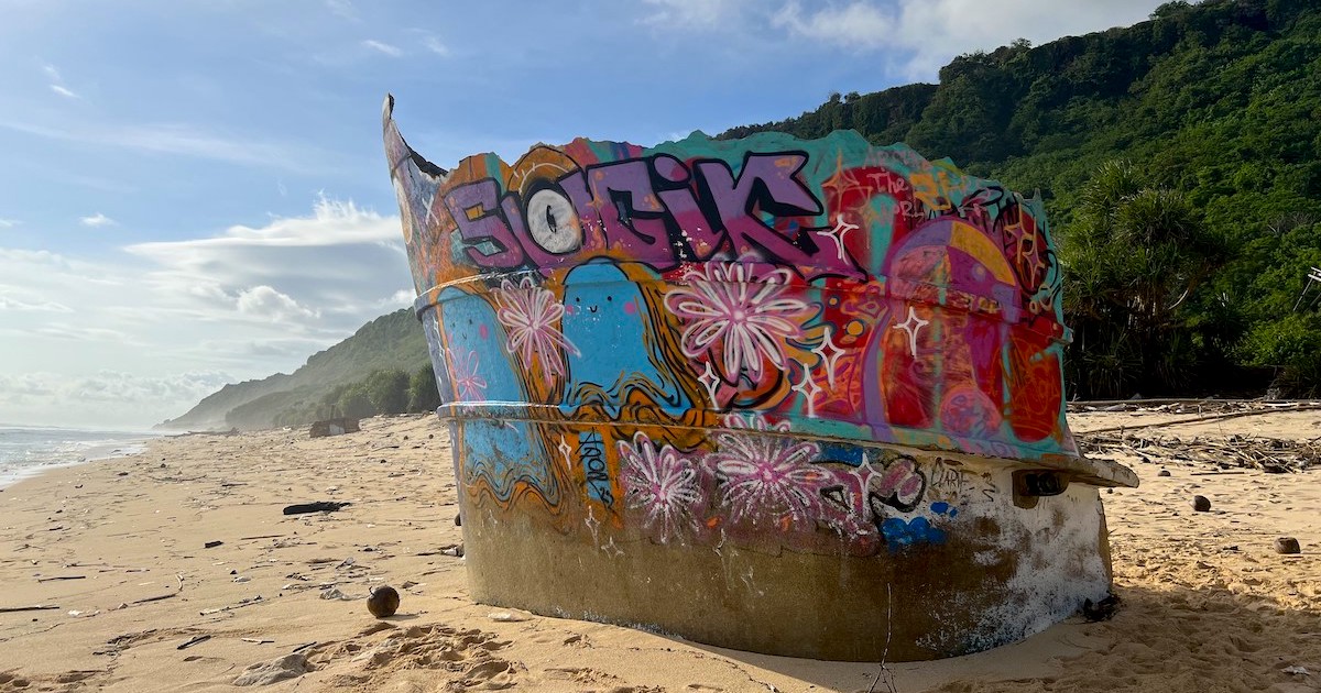 A shipwreck with colourful graffiti on Nunggalan Beach.
