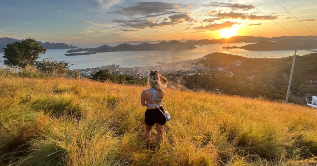 Blonde girl wears black cotton shorts and a blue sports bra on Mount Tapyas in Coron.