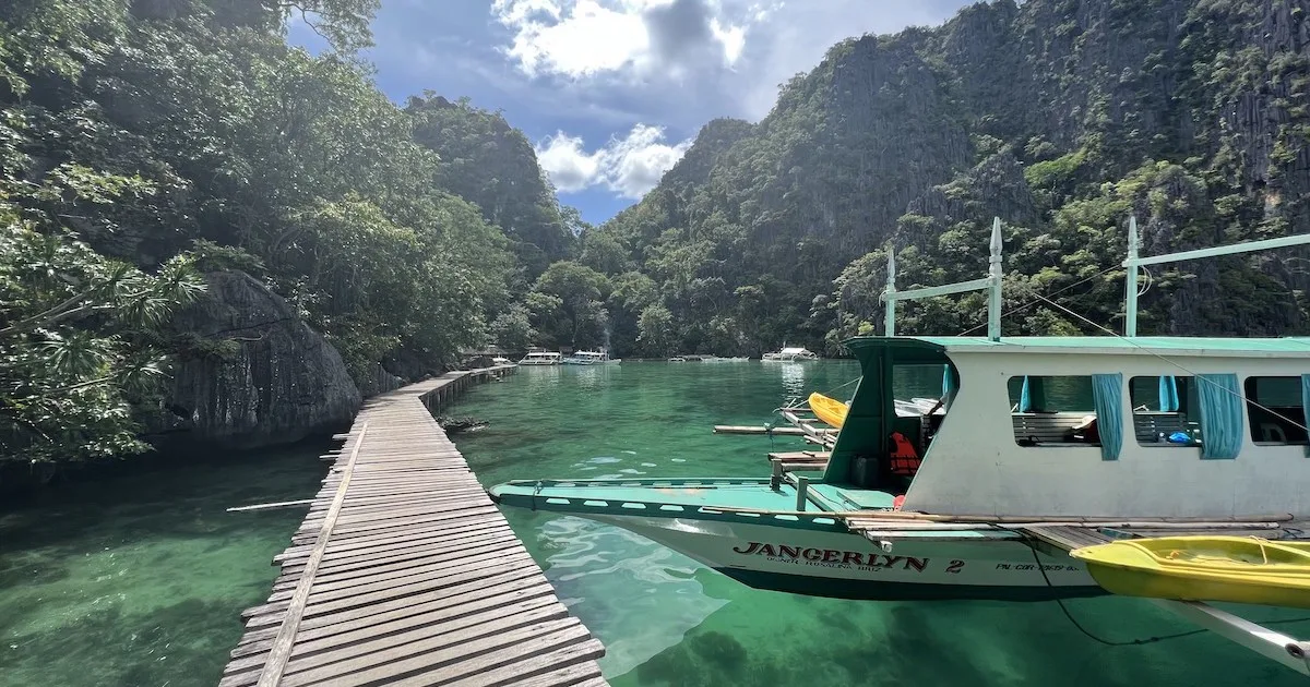 A bangka boat floats next to the boardwalk at the port for Kayangan Lake in El Nido.