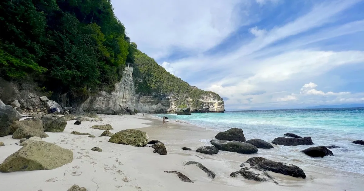 Rocks scatter a sandy shoreline.