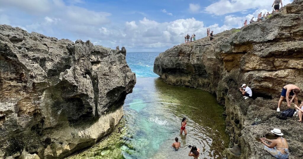 Tourists paddle in Angel's Billabong , a natural pool in Nusa Penida