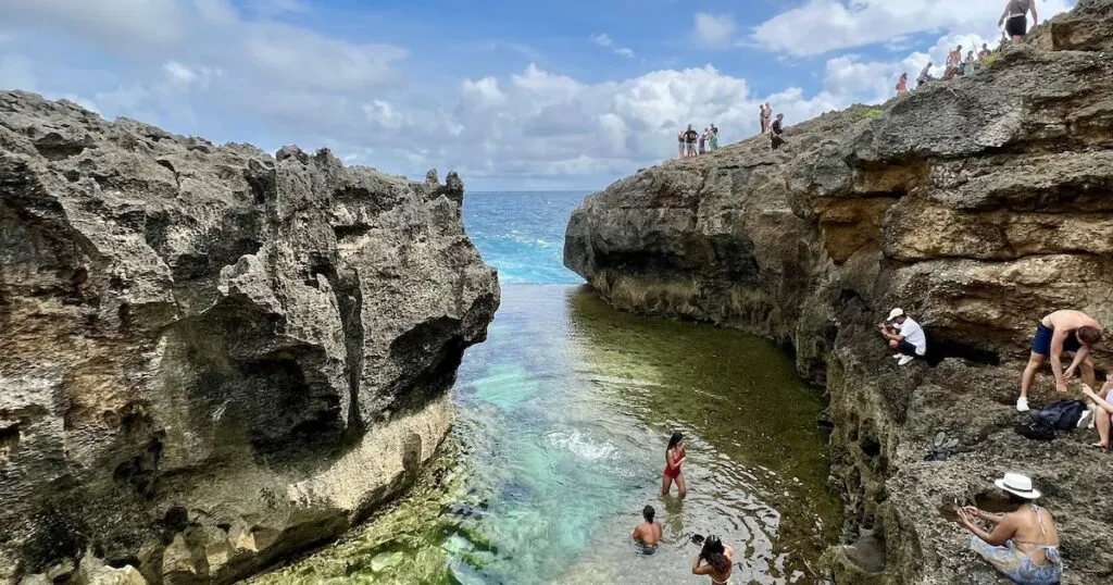Tourists paddle in Angel's Billabong , a natural pool in Nusa Penida