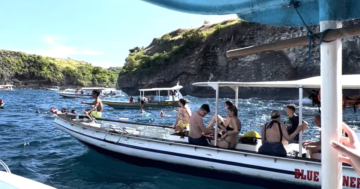 Several boats float on choppy water at Manta Bay in Nusa Penida