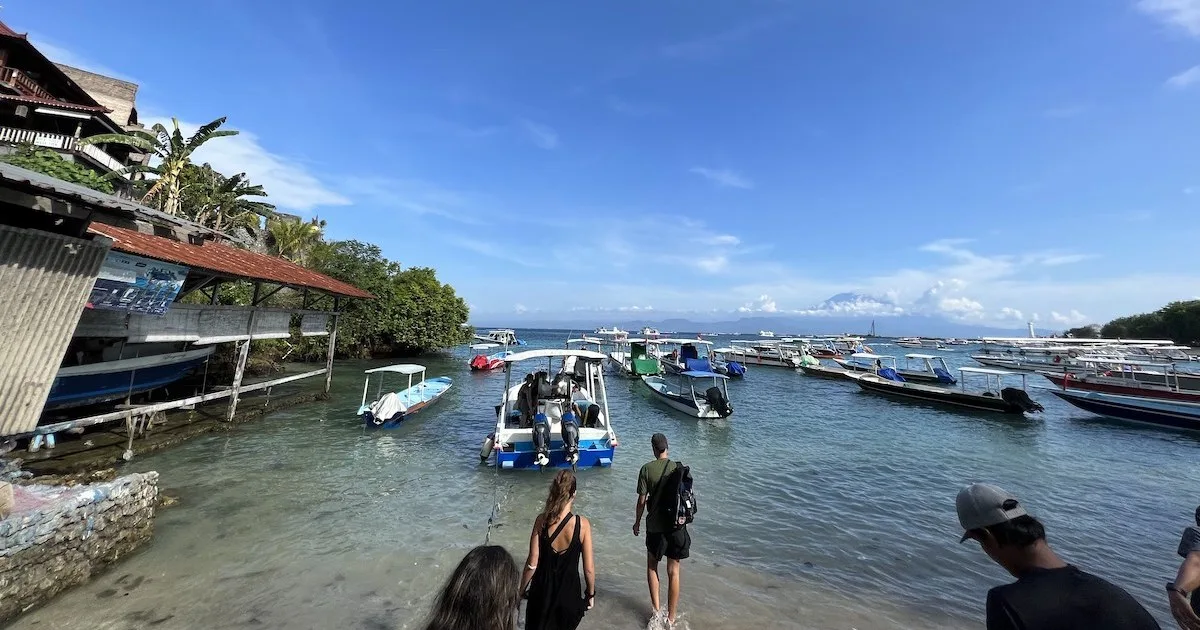 People walk into the water at Toyapakeh harbour in Nusa Penida.