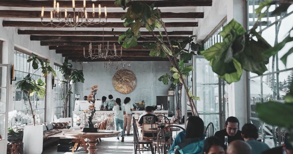 A hipster coffee shop with plants and sofas in Bali.