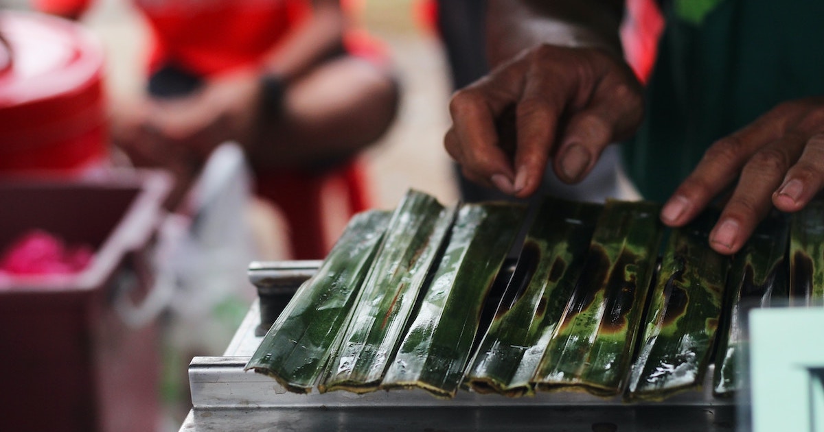 Balinese man prepares a bamboo leaf to grill gluten free food in Bali.