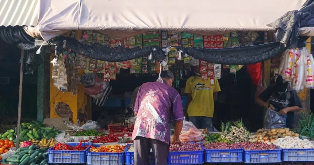 Local Balinese man picks out fruit at a local market.