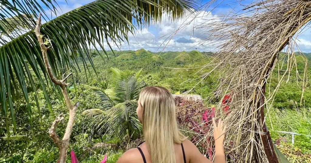 Girl looks over a series of dome-shaped hills in Bicol region in the Philippines.