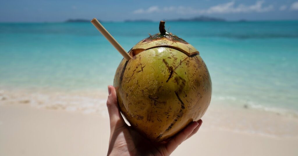 A straw in a coconut on a beach in the Philippines.