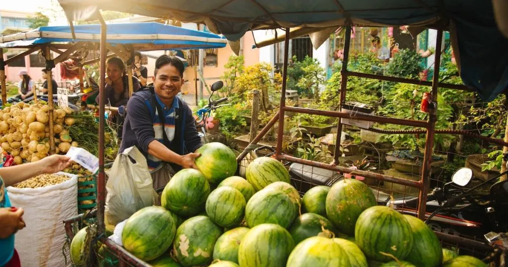 Smiling Filipinos tend to fruit at a market stall in Manila.