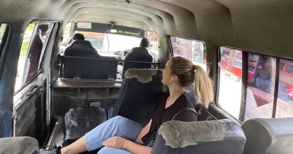 Girl wearing jeans and a black shirt on an old public bus in West Sumatra.