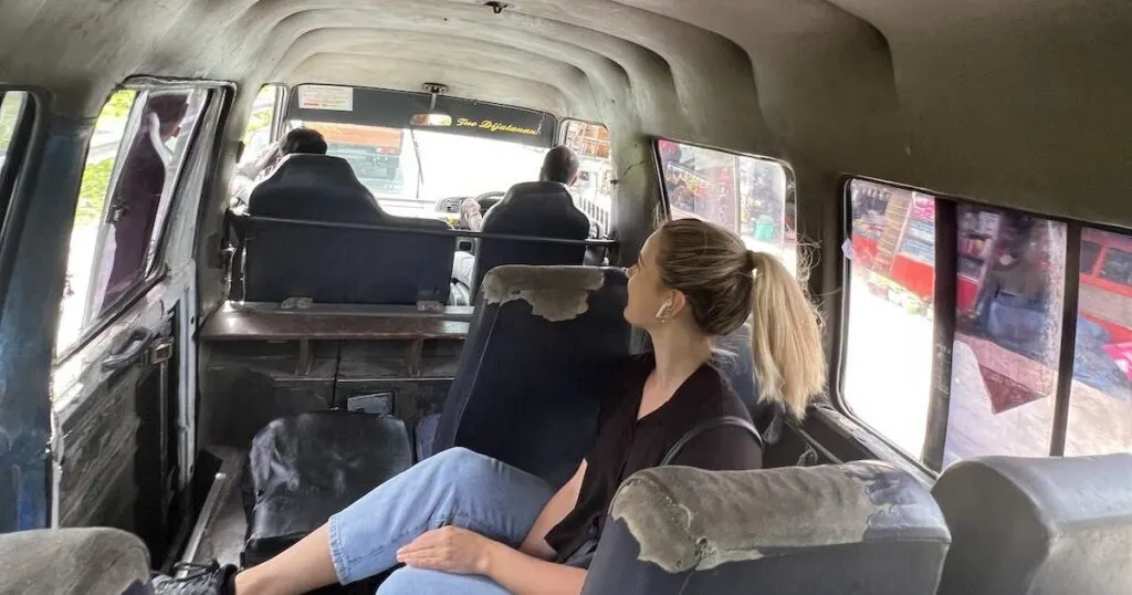 Girl wearing jeans and a black shirt on an old public bus in West Sumatra.