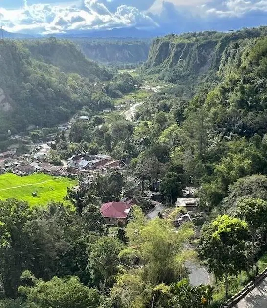 Sianok Valley in Bukittinggi, featuring a hairpin bend and houses.