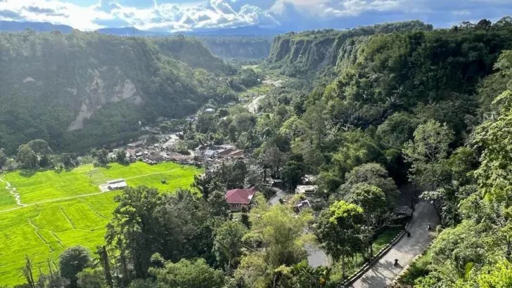 Sianok Valley in Bukittinggi, featuring a hairpin bend and houses.