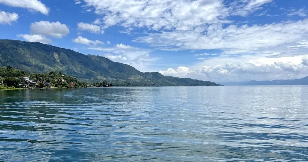 Blue water in the morning at Lake Toba, a backpacking Sumatra destination.