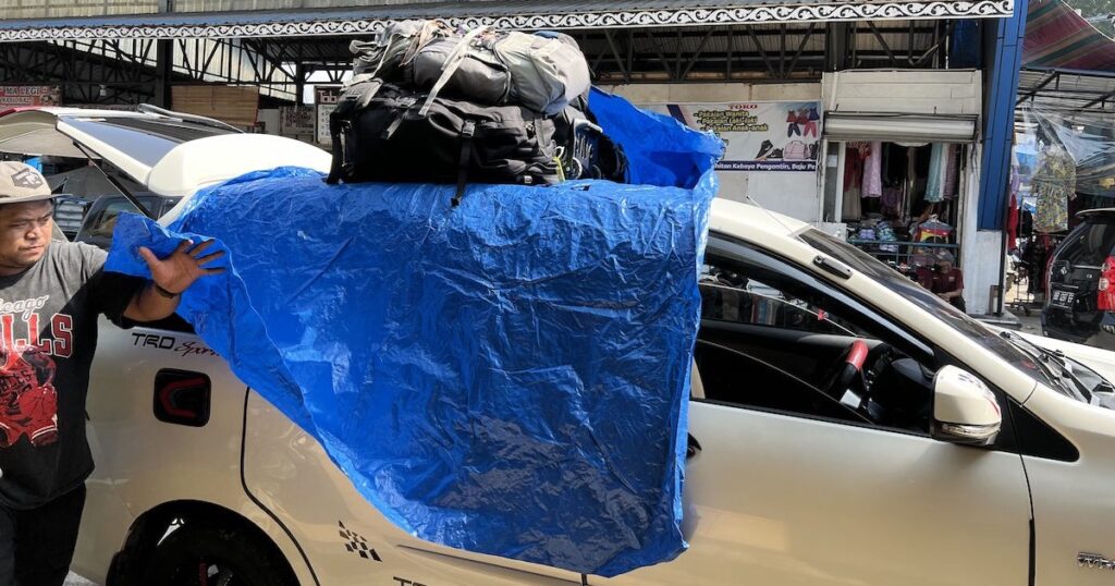 Backpacks and tarp on top of a car in Sumatra, the typical transport when backpacking Sumatra.