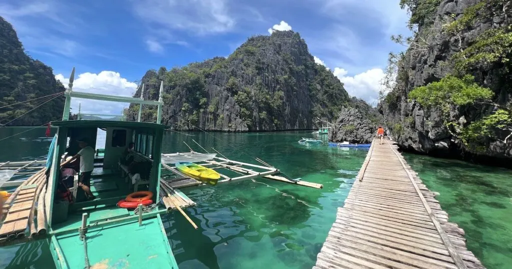 Bangka boat leading Coron island hopping tours rests next to a boardwalk outside of Kayangan Lake.
