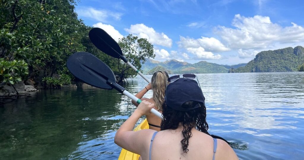 Two girls kayaking through Small Lagoon in Coron.