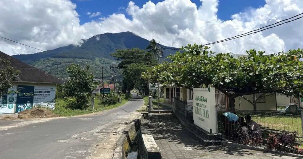 An empty road in Koto Gadang village with hills in the background.