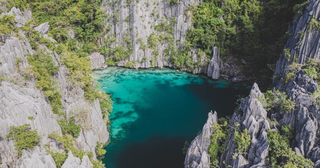 Aerial view of turqouise waters in Twin Lagoon in Coron surrounded by limestone cliffs.
