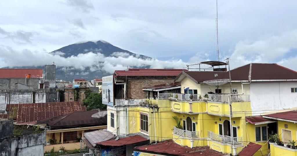 View of Mount Merapi and town roofs from Air Kuning Hostel in Bukittinggi.