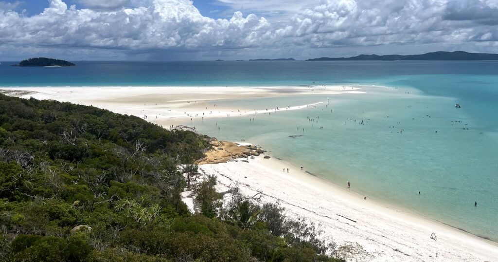 White silica sand at Whitehaven Beach dotted with people, viewed from a lookout.