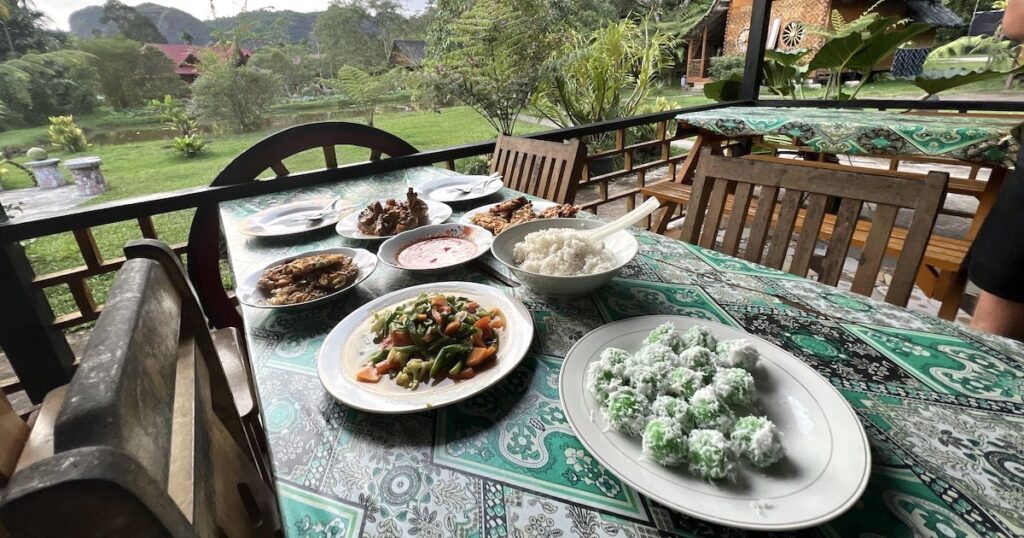 Indonesian dishes including klepon and coconut curry on a table at Abdi homestay following a cooking class.
