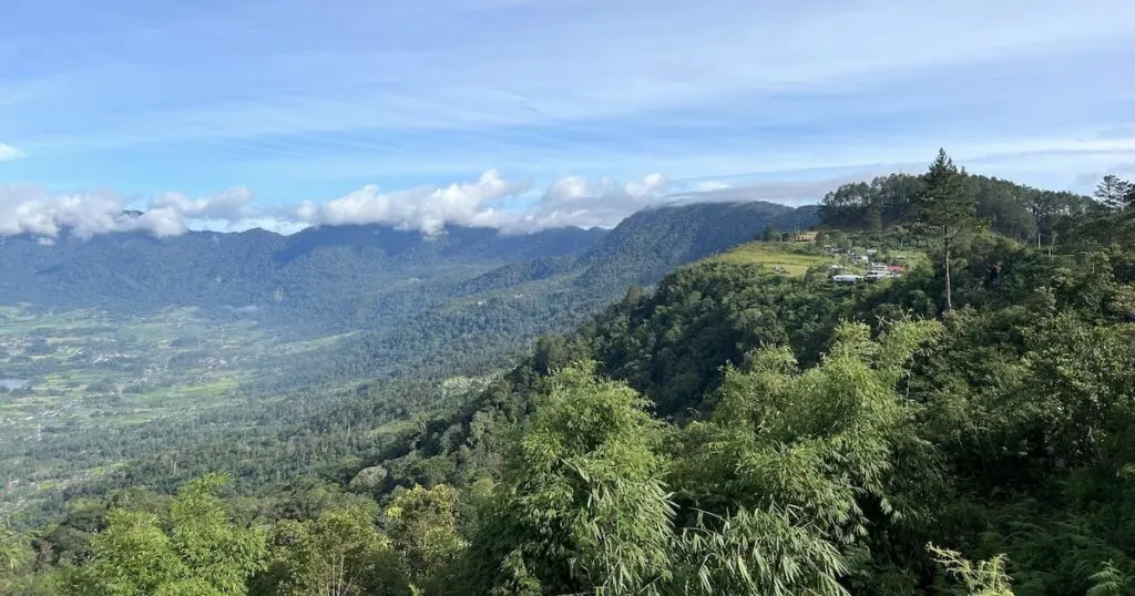 The ridge above the Maninjau crater lake in west Sumatra, with forested slopes descending to the shore.