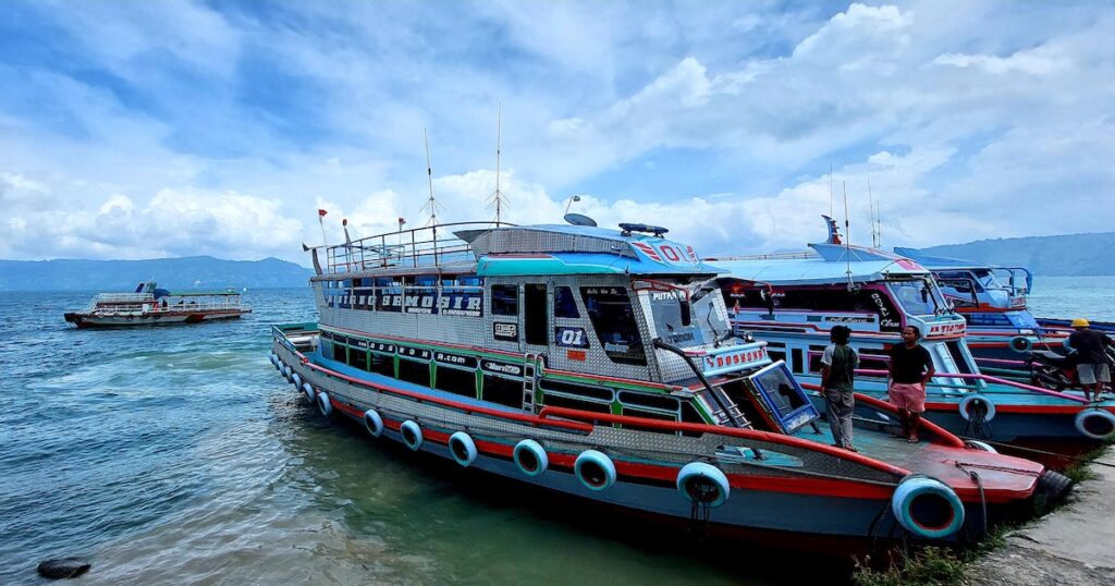 Ferries wait next to Samosir Island, a top Lake Toba travel destination.