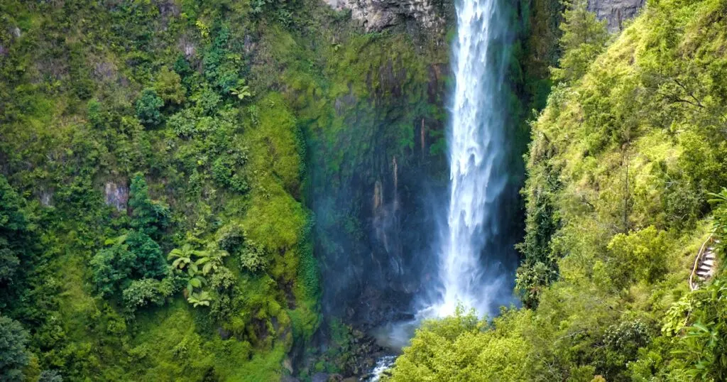 Sipiso Piso waterfall near Lake Toba surrounded greenery.